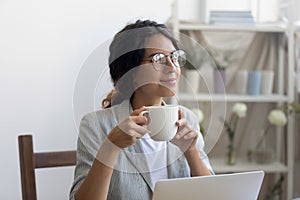 Female designer drinking coffee satisfied with self realization in profession