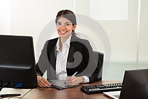 Female designer with graphic tablet at desk