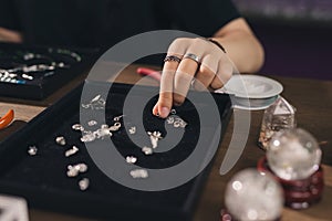 Female designer making jewelries at a jewelry shop