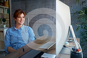 Female designer smiling and working at workplace photo