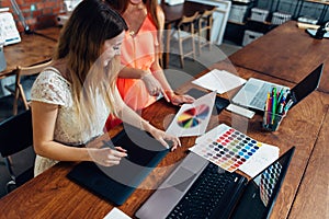 Female designer working with client at desk in her office