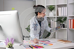 Female designer working in graphic design Choose colors for working on tablets and computer designs.