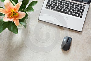 Female desktop with a open laptop and flowers on vintage background. Top view, copy space.