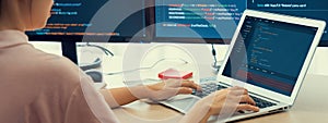 Female developer coding on laptop while computer display program. Burgeoning.