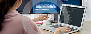 Female developer coding on laptop while computer display program. Burgeoning.