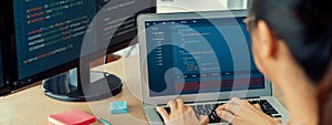 Female developer coding on laptop while computer display program. Burgeoning.