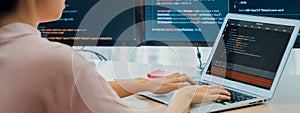 Female developer coding on laptop while computer display program. Burgeoning.
