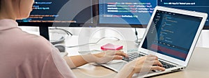 Female developer coding on laptop while computer display program. Burgeoning.