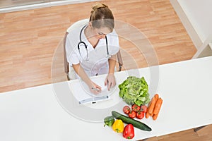 Female dietician writing in diary photo