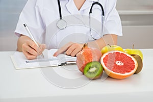 Female dietician writing prescription photo