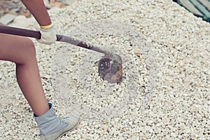 Female diggings stone for the cement with shovel.