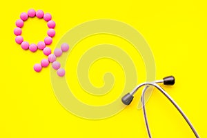 Female diseases concept. Stethoscope near female sign on yellow background top view copy space