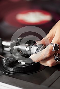 Female DJ adjusting turntable tonearm