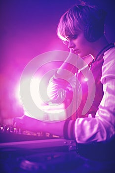 Female dj listening to headphones while playing music