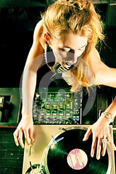 Female DJ at the turntable in Club