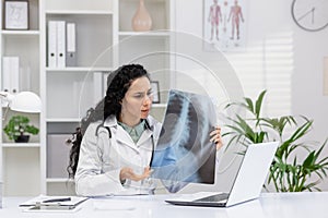 Female doctor analyzing X-ray image in clinic office