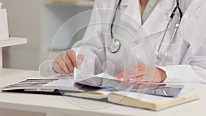 Female doctor analyzing x-rays and working while sitting at table in clinic office spbi.