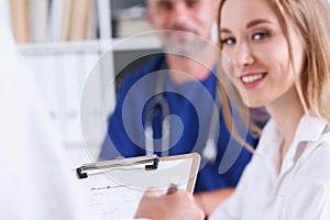 Female doctor arm hold silver pen filling patient complaints