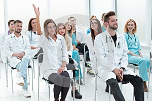 Female doctor asks a question to the lecturer during the seminar