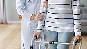 Female doctor assist senior patient with walking frame