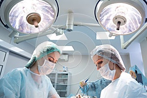 Female doctor and assistant during operation in surgery room