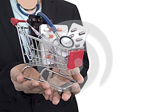 Female Doctor with black suit is holding small shopping cart With colorful pills , injection syringe and stethoscope.