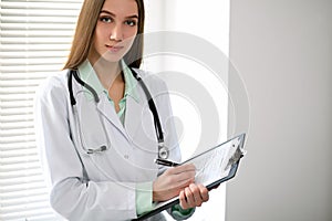 Female doctor brunette sitting at the table near the window in hospital