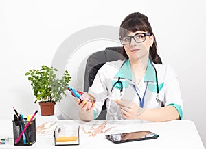 Female doctor cardiologist with a mock heart in hands in a doctor\'s office. The concept of treatment and heart surgery