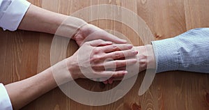 Female doctor caregiver stroking wrinkled hand of old man.