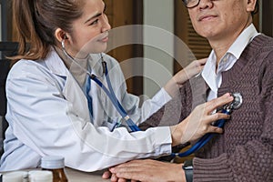 The female doctor in charge holds a stethoscope and listens to the patient. Doctor checking heartbeat examining retired