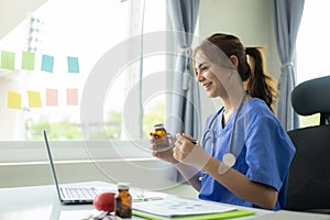 Female doctor chats online with patient Attractive female doctor working remotely from hospital in office