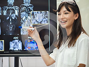Female doctor check film x-ray image for patient medical care. Surgeon woman examining x-ray film of human body part then