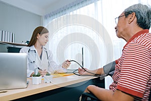 Female doctor checking blood pressure ff senior man patient.