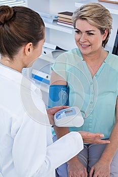 Female doctor checking blood pressure of a patient