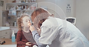Female doctor checking a cute little girl