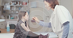 Female doctor checking a cute little girl