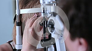 Female Doctor checking eyes with modern medical device. Eye examining at modern hospital.