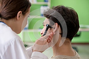 The female doctor checking patient`s ear during medical examination