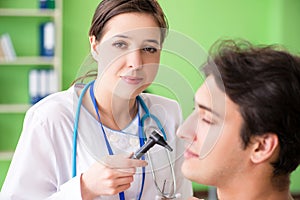The female doctor checking patient`s ear during medical examination