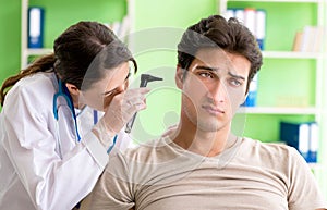 Female doctor checking patient`s ear during medical examination