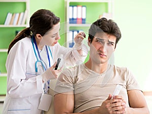 Female doctor checking patient`s ear during medical examination