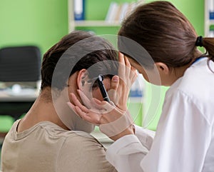 Female doctor checking patient`s ear during medical examination