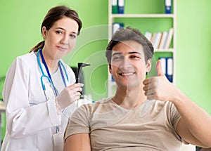 Female doctor checking patient`s ear during medical examination