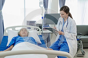 Female doctor with clipboard talking with elderly female patient at hospital Senior woman or doctor