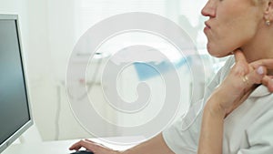 A female doctor is concentrating on working at the computer in the office.