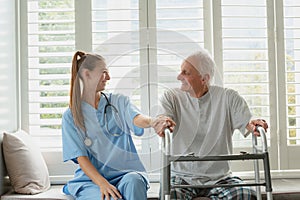 Female doctor consoling active senior man on window seat