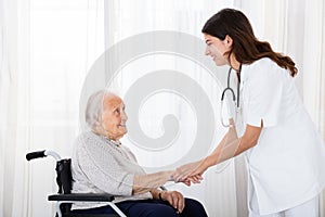 Female Doctor Consoling Disabled Senior Patient