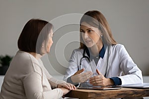 Female doctor consult mature patient at clinic