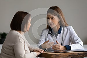 Female doctor consult mature patient at clinic photo