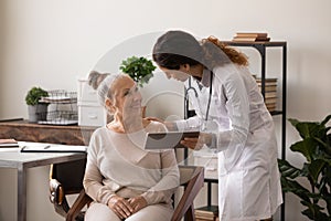 Female doctor consult senior patient using tablet